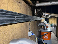 a row of metal pipes on the side of a building