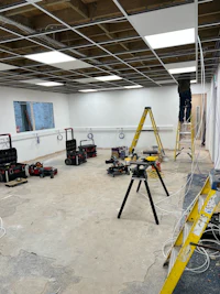 a room with a man working on a ladder
