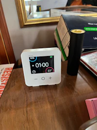 a digital clock sitting on a wooden table