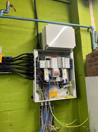 a green electrical box with wires attached to it