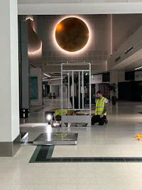 two men working on a floor in an airport