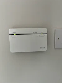 a white device is mounted on the wall of a room