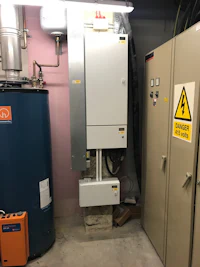 a hot water heater in a garage with a sign on it
